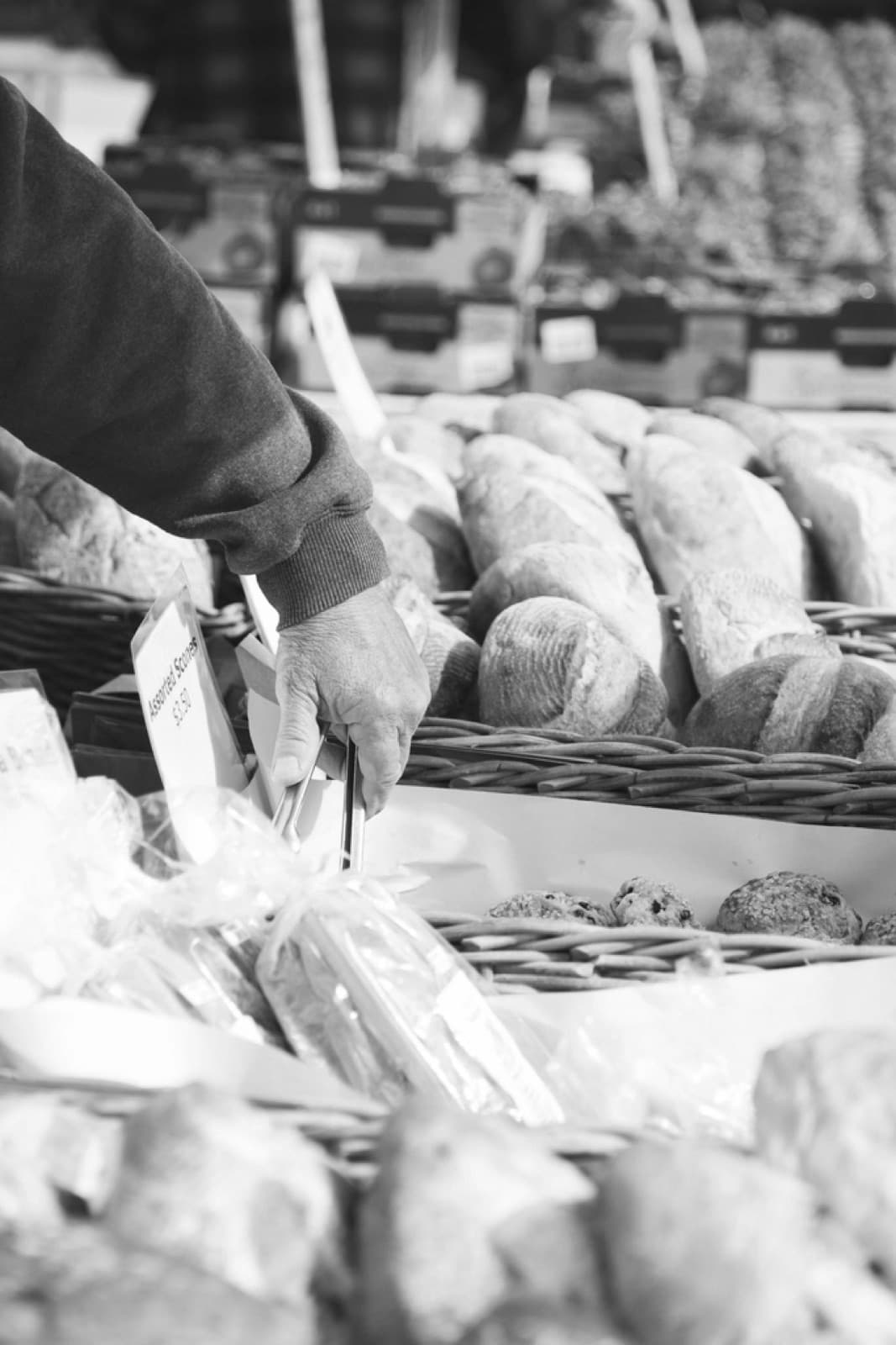 Une main saisissant un pain sur l'étal d'un commerce